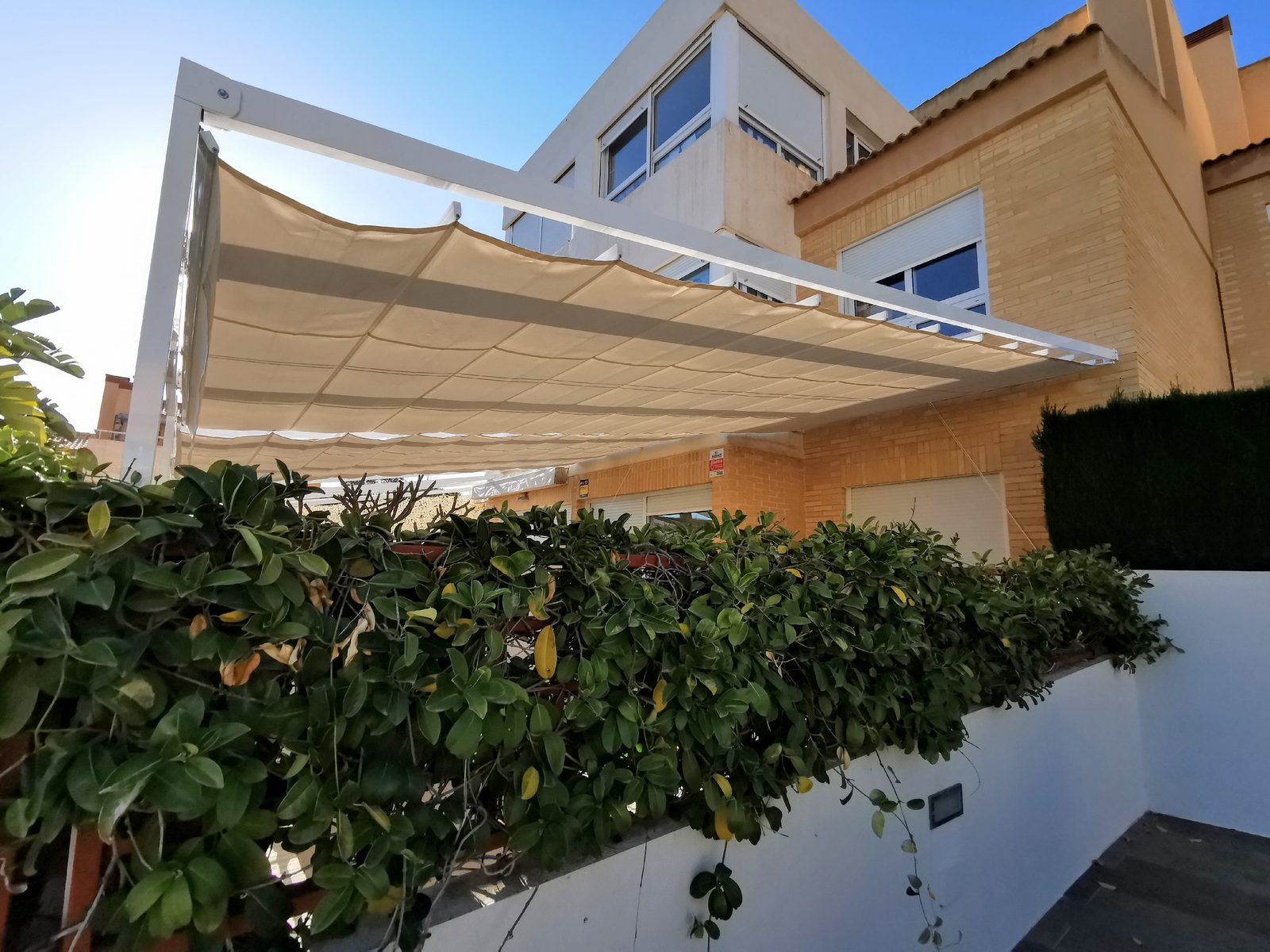 Pérgola de aluminio con screen ZIP instalada junto a piscina en Benidorm