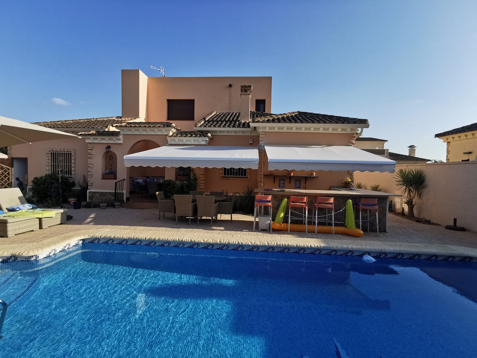 Toldo extensible junto a piscina en villa de la Vega Baja